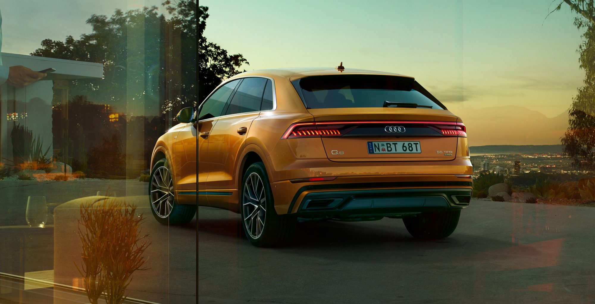 Orange Audi Q8 parked in a driveway at nighttime