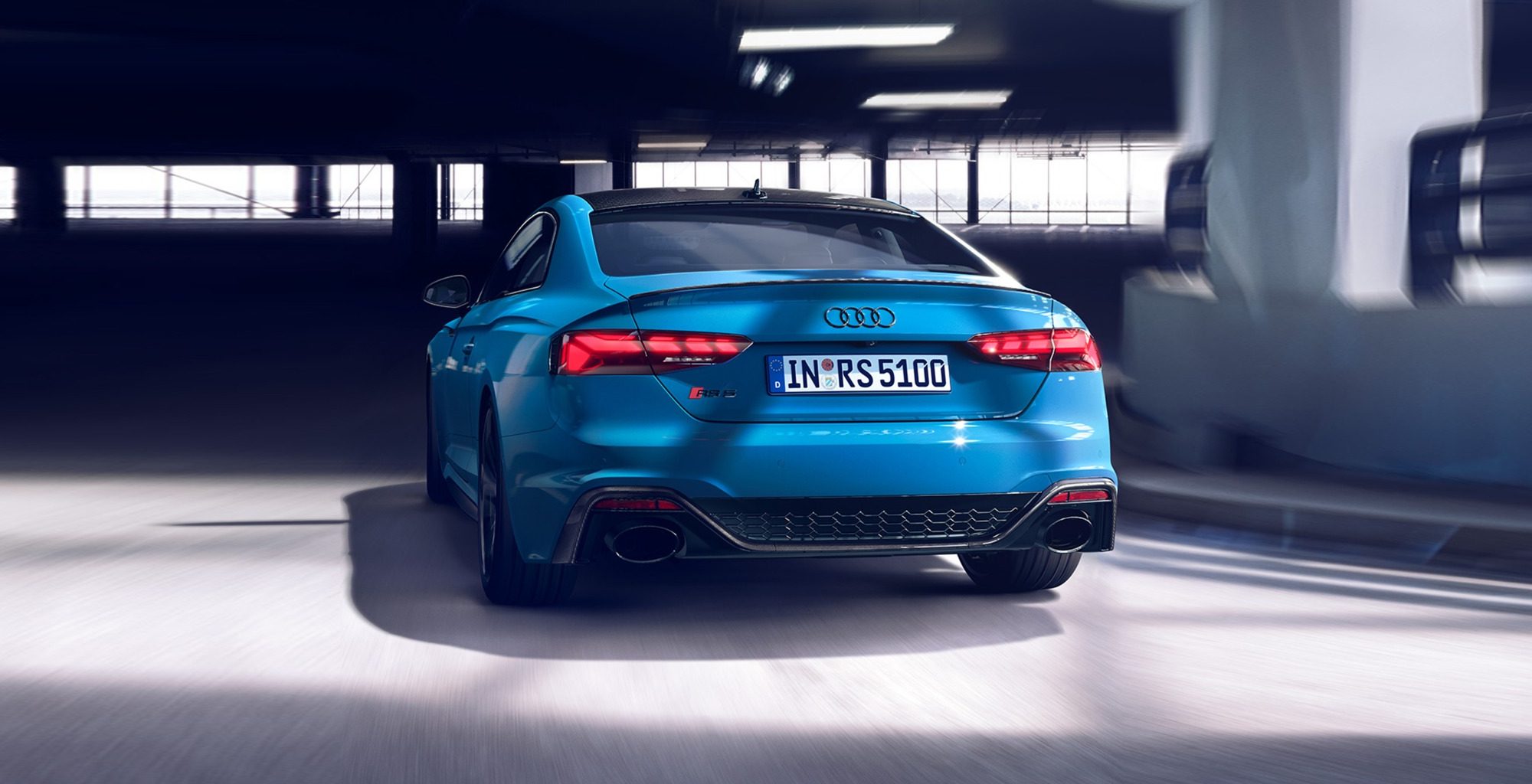 the back of Audi RS5 Coupe in blue in an urban setting
