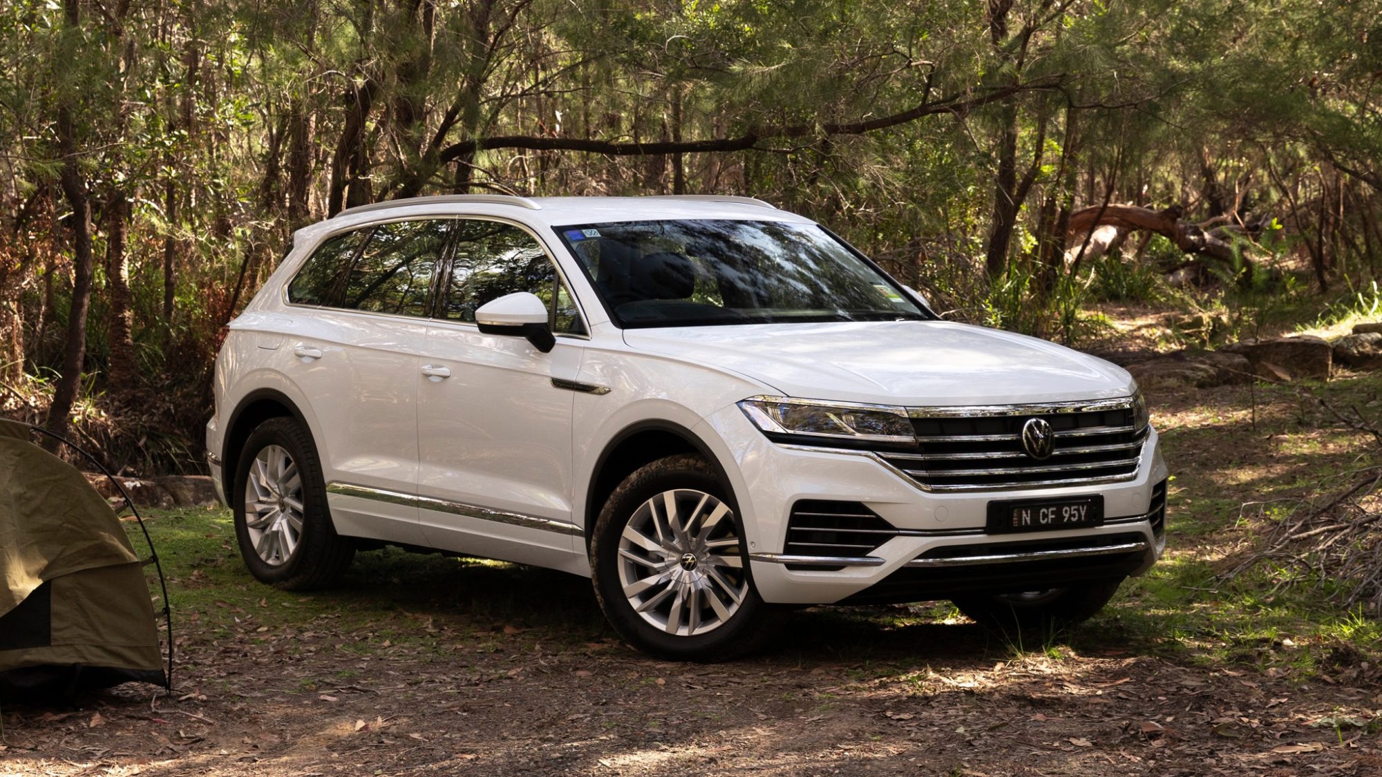 White Volkswagen Touareg parked at a campsite with a swag to the left